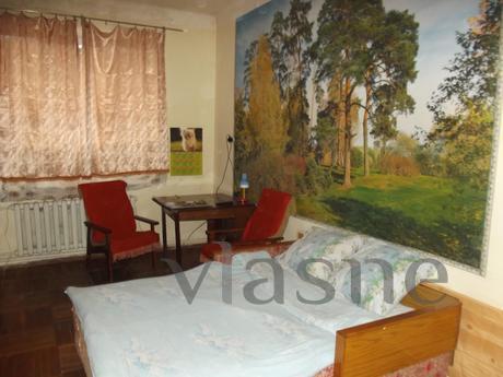 The apartment has two sofas, wall units, fridge, TV, dishes,